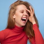 Cheerful redhead woman laughing at joke