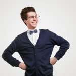 Cheerful young student in bow tie and eyeglasses